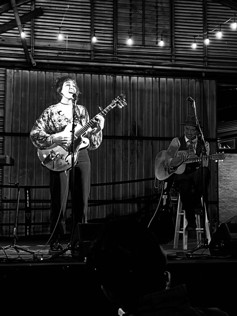 Women singing on stage at PC Songwriter's Festival